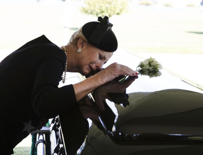 In this photo provided by the family of John McCain, Cindy McCain lays her head on the casket of Sen. John McCain, R-Ariz., during a burial service at the cemetery at the United States Naval Academy in Annapolis, Md., on Sunday, Sept. 2, 2018. (David Hume Kennerly/McCain Family via AP)