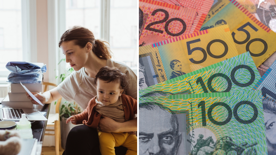 A woman holds a baby while going over budget documents and Australian currency.
