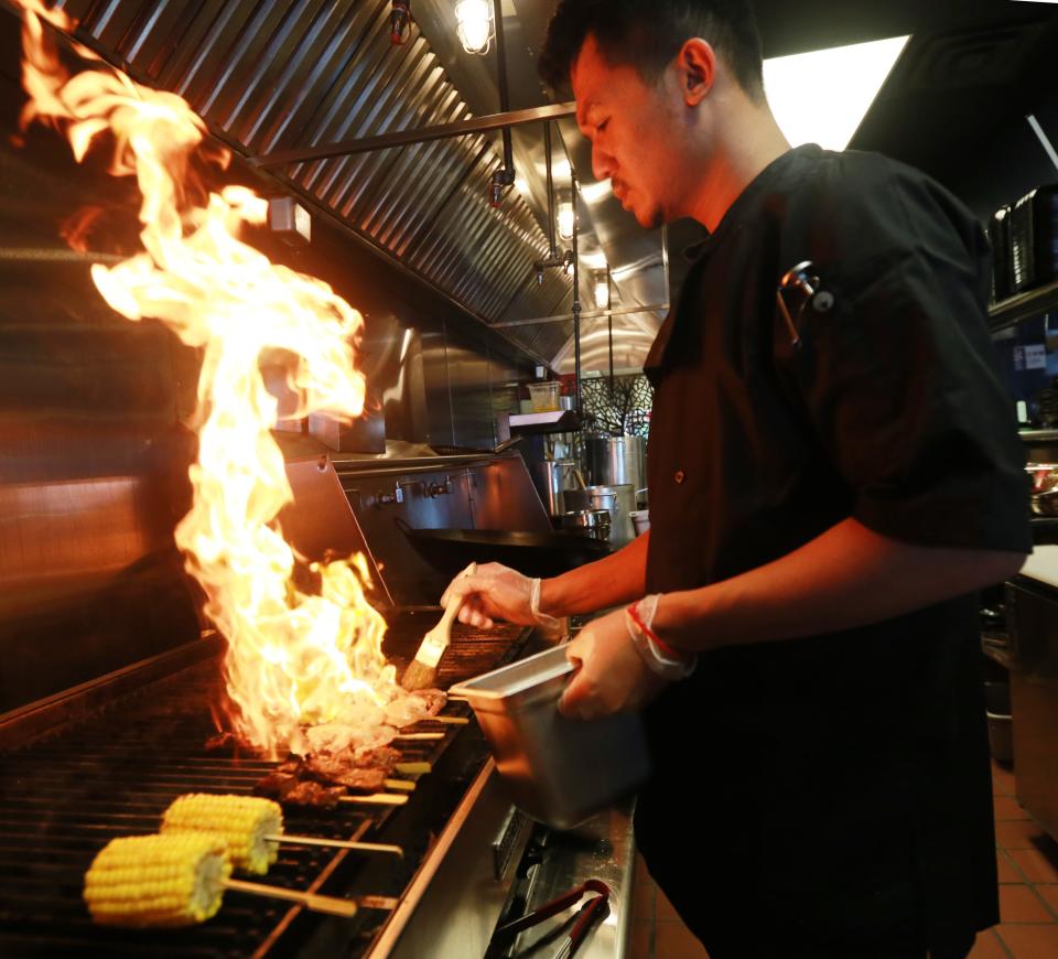 Owning partner and chef Sotheavong Meas cooks on the grill at Malis in Raynham on Tuesday, July 19, 2022. 