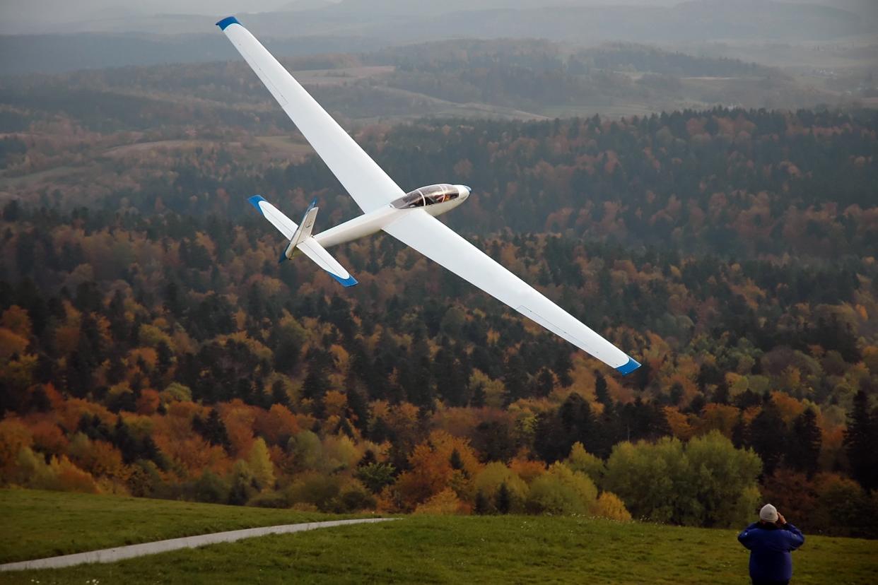glider in the air over trees in autumn