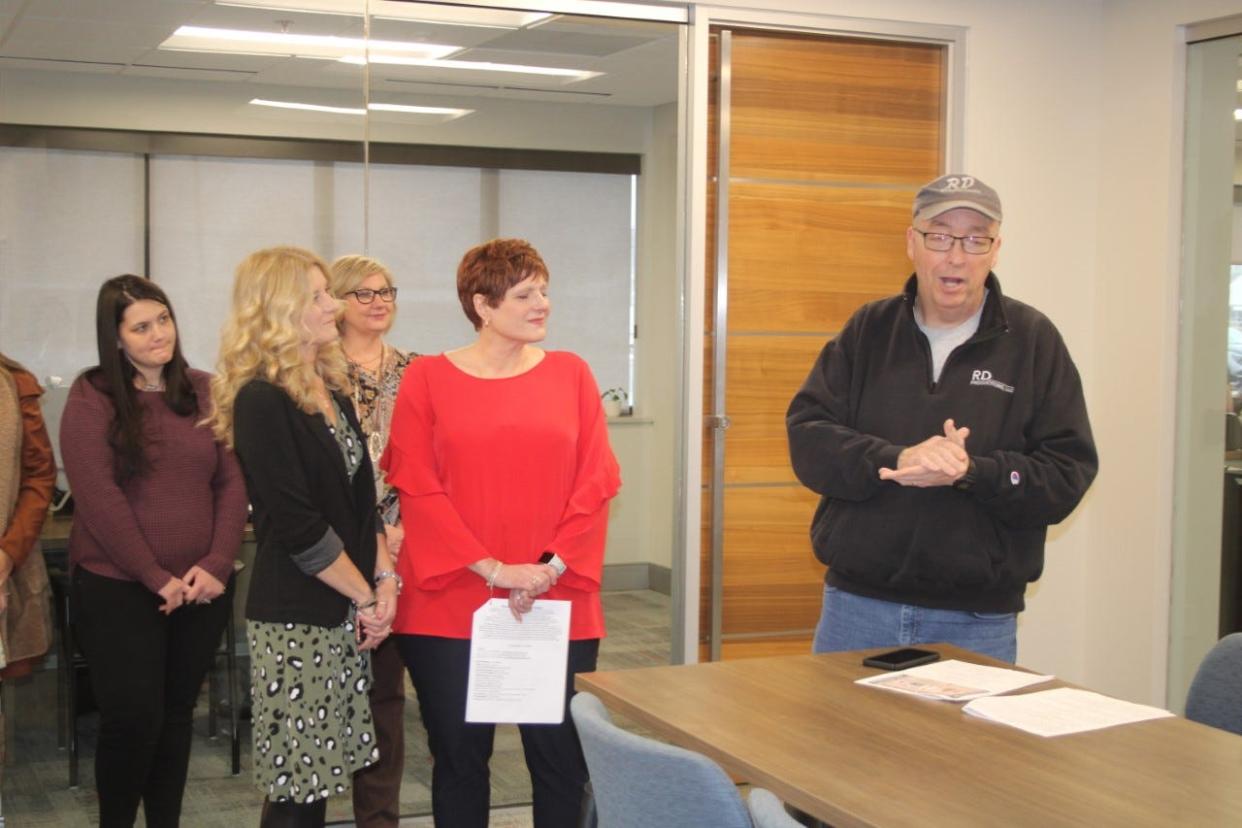 Rob Helms, of RD Promotions LLC, announces the lineup for the Morgan County Fair Christian Benefit Concert at Home Bank. Employees of the bank attended the event.