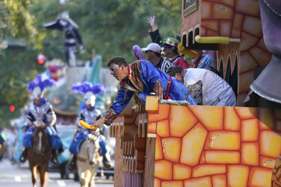 A rider tosses trinkets from a float during a parade dubbed "Tardy Gras," to compensate for a cancelled Mardi Gras due to the COVID-19 pandemic, in Mobile, Ala., Friday, May 21, 2021. (AP Photo/Gerald Herbert)