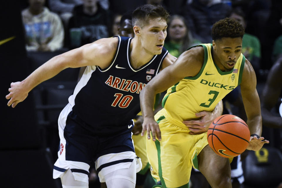 Arizona forward Azuolas Tubelis (10) reaches around to try to steal the ball from Oregon guard Keeshawn Barthelemy (3) during the first half of an NCAA college basketball game Saturday, Jan. 14, 2023, in Eugene, Ore. (AP Photo/Andy Nelson)