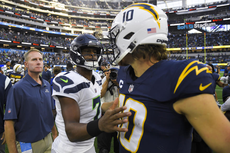 Seattle Seahawks quarterback Geno Smith (70) greets Los Angeles Chargers quarterback Justin Herbert (10) after their NFL football game Sunday, Oct. 23, 2022, in Inglewood, Calif. The Seahawks won 37-23. (AP Photo/Mark J. Terrill)
