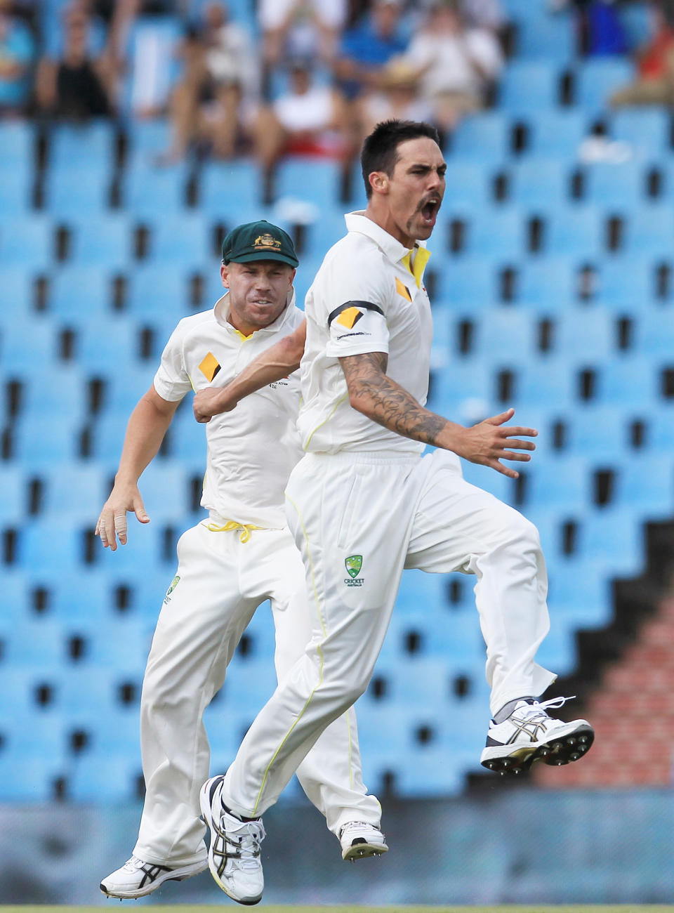 Australia's bowler Mitchell Johnson, right, with teammate David Warner, left, reacts after dismissing South Africa's batsman Faf du Plessis, for 3 runs on the second day of their their cricket Test match at Centurion Park in Pretoria, South Africa, Thursday, Feb. 13, 2014. (AP Photo/ Themba Hadebe)