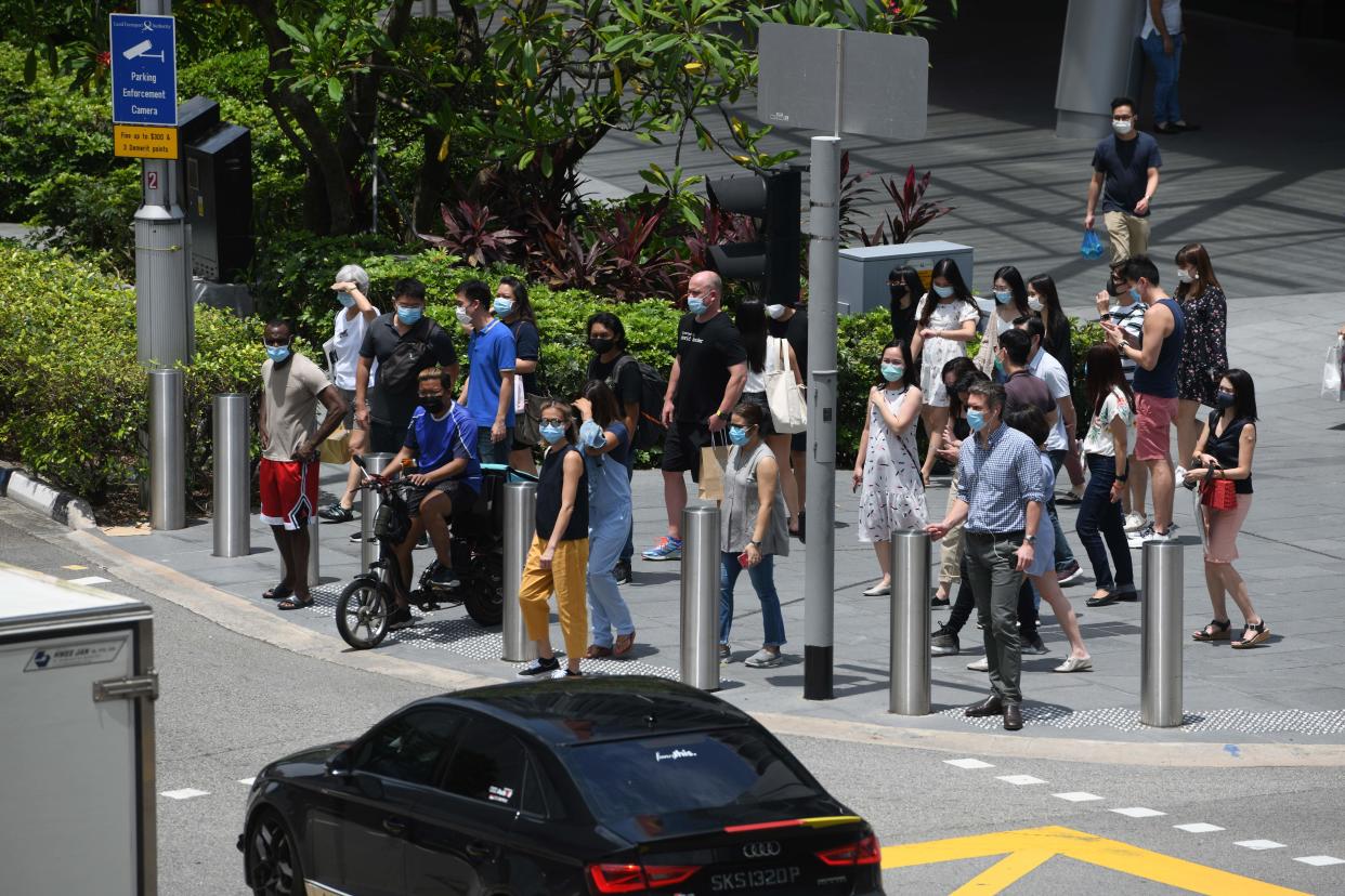 Pedestrians wait to cross the street at a junction along the Orchard Road shopping district in Singapore on September 25, 2020. (Photo by ROSLAN RAHMAN / AFP) (Photo by ROSLAN RAHMAN/AFP via Getty Images)