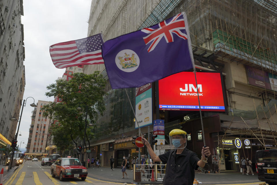 FILE - In this file photo taken Sunday, May 24, 2020, a protester wave a U.S. national flag and a Hong Kong colonial flag during a protest against Beijing's national security legislation in Causeway Bay in Hong Kong. China is taking matters into its own hands after months of tumultuous anti-government protests in Hong Kong last year that often descended into tear gas and clashes. In a surprise move, the central government announced last week that it would develop laws to outlaw secession, subversion of state power, terrorist acts and foreign interference in Hong Kong. The National People's Congress is expected to ratify the move Thursday, and the laws could be finalized this summer. (AP Photo/Vincent Yu, File)