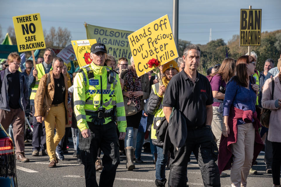 ENGLAND, LITTLE PLUMPTON, FLYDE, LANCASHIRE, UNITED KINGDOM - 2018/10/20: Protesters are seen during the march towards the frack site with a police officer seen walking alongside them.  Protesters from the United Kingdom descended on the small village of Little Plumpton to protest against the recent decision for the Cuadrilla frack site at Preston New Road to resume. The controversial site has been met with fierce backlash and disapproval from local residents to those in higher places of government. (Photo by Stewart Kirby/SOPA Images/LightRocket via Getty Images)