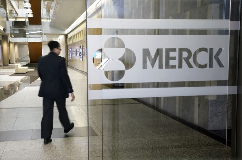 FILE - In this Dec. 18, 2014, file photo, a person walks through a Merck company building in Kenilworth, N.J. COVID-19 infections weighed Merck with so many people avoiding visits to hospitals or even the doctor early in the first quarter. The pharmaceutical company on Thursday, April 29, 2021, reported first-quarter earnings of $3.18 billion.(AP Photo/Mel Evans, File)