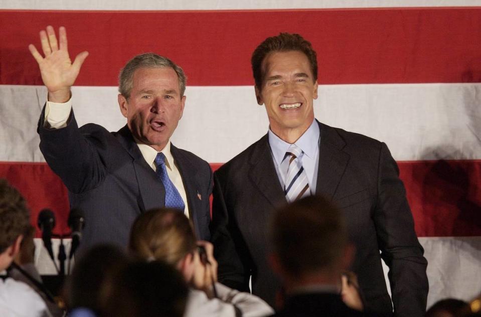 President George W. Bush waves to the crowd with Gov.-elect Arnold Schwarzenegger following Bush’s speech about terrorism, Iraq and the economy at the Radisson Hotel and Convention Center in San Bernardino on Oct. 16, 2003.