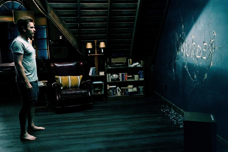 ewan mcgregor looking at a wall that reads "murder"