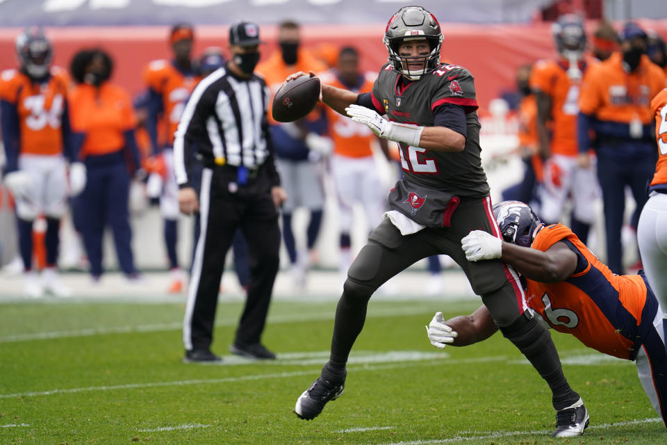 Tampa Bay Buccaneers quarterback Tom Brady throws a pass under pressure from Denver Broncos defensive end Shelby Harris, right, during the first half of an NFL football game Sunday, Sept. 27, 2020, in Denver. (AP Photo/David Zalubowski)