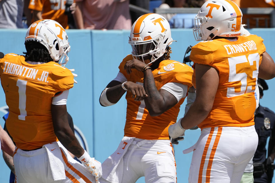 Tennessee quarterback Joe Milton III, celebrates his touchdown with teammates wide receiver Dont'e Thornton Jr. (1) and offensive lineman Jeremiah Crawford (53) in the second half of an NCAA college football game against Virginia, Saturday, Sept. 2, 2023, in Nashville, Tenn. Tennessee won 49-13. (AP Photo/George Walker IV)