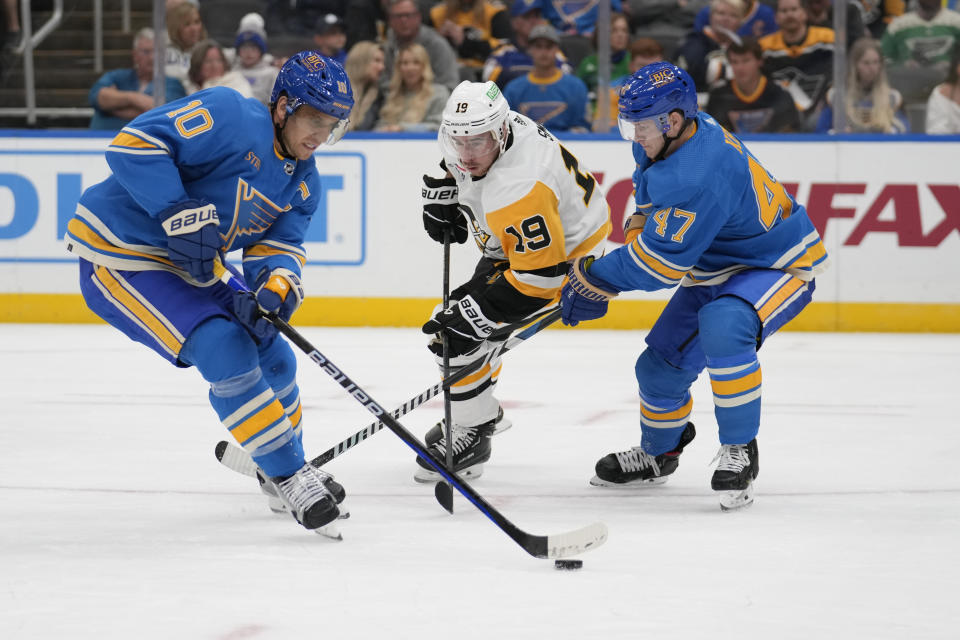 St. Louis Blues' Brayden Schenn (10) controls the puck as teammate Torey Krug (47) and Pittsburgh Penguins' Reilly Smith (19) get in on the play during the third period of an NHL hockey game Saturday, Oct. 21, 2023, in St. Louis. (AP Photo/Jeff Roberson)