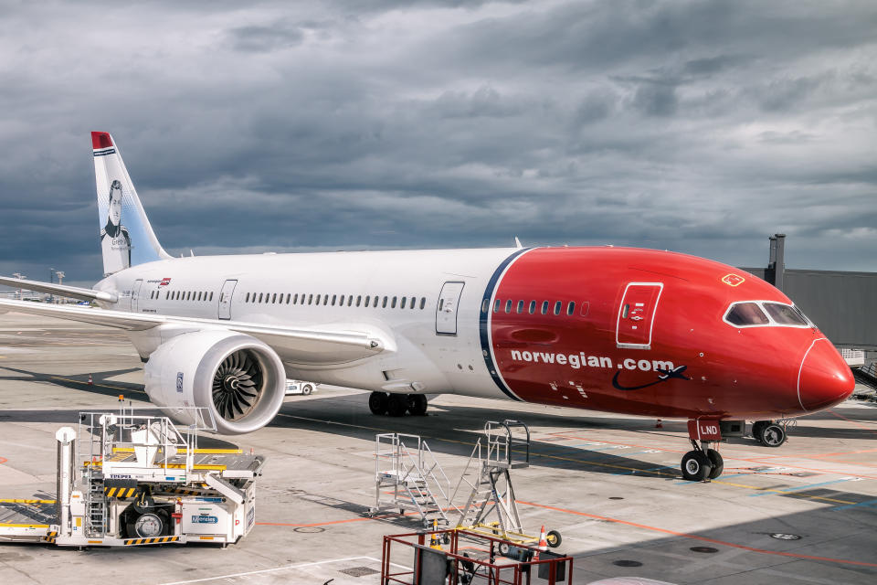 Copenhagen, Denmark – June 9, 2015: Norwegian, Boeing 787 – Dreamliner, is parking at terminal at Copenhagen Airport. They are preparing for takeoff before storm comes.