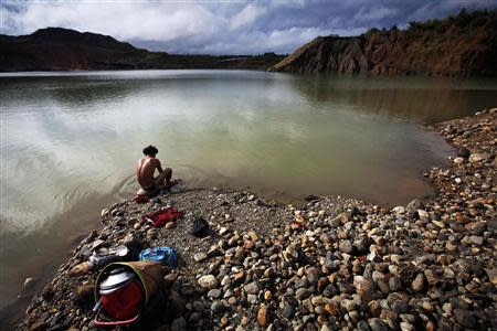 A hand-picker washes himself after searching for jade through rubble dumped by mining companies at a jade mine in Hpakant township, Kachin State July 7, 2013. REUTERS/Minzayar