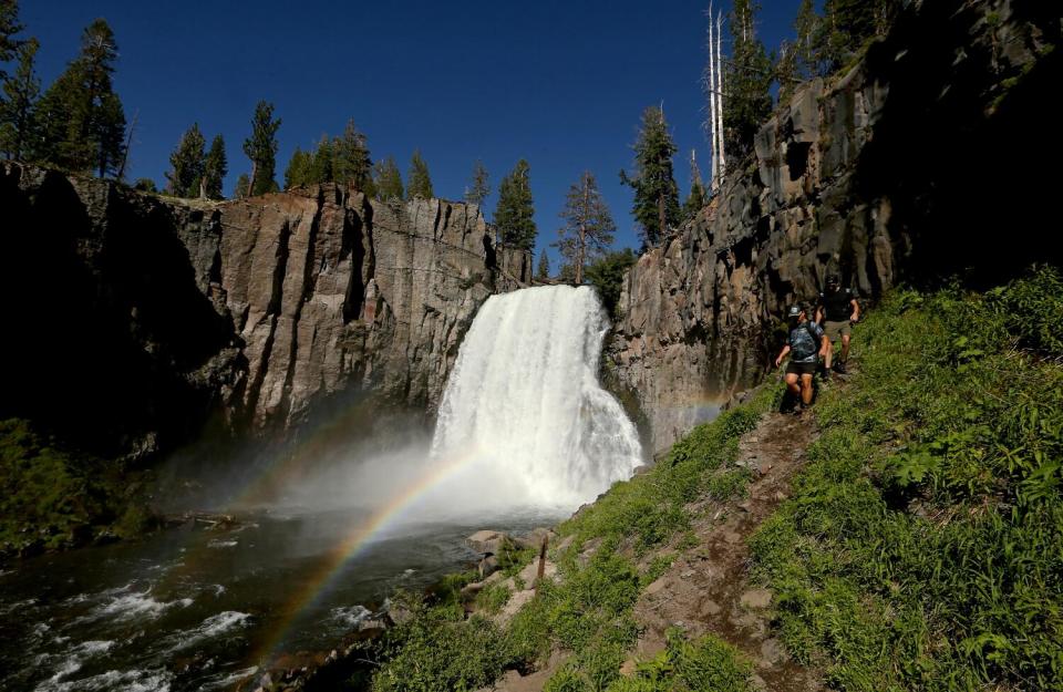 Hikers follow a trail along Rainbow Falls in the Devils Postpile National Monument.