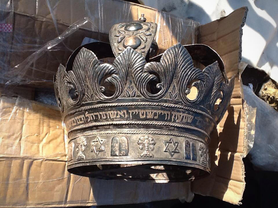 This image released by Egypt's Ministry of Antiquities on Friday, April 18, 2014 shows a crown from a cache of Jewish religious artifacts seized by officials in Damietta, Egypt that smugglers wanted to ship to Belgium at one of the country's main ports. Antiquities Minister Mohammed Ibrahim said in a statement Friday that officials found the artifacts while searching cargo Thursday at the coastal city of Damietta. Among the artifacts are a cylindrical wooden box plated in silver, which would have held Torah scrolls. Officials also found a silver knife dating to roughly 1890 with inscriptions, and bells commonly hung in synagogues. (AP Photo/Egypt Ministry of Antiquities)