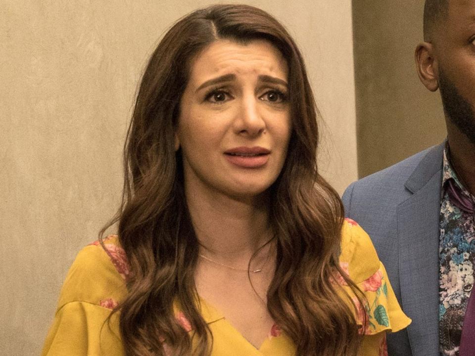 Nasim Pedrad as Aly in a yellow dress and pregnant with Lamorne Morris as Winston. Both look distressed