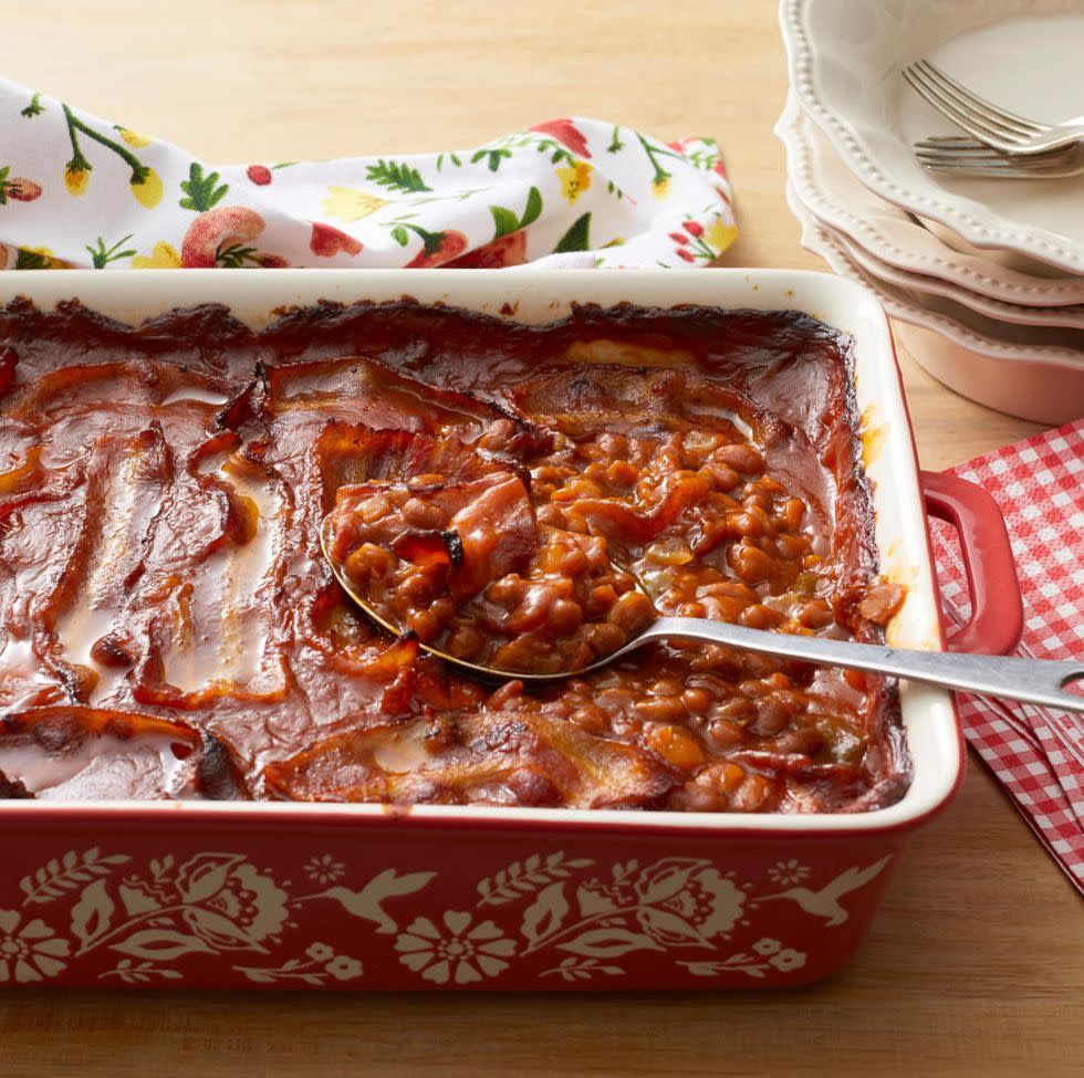 baked beans in red casserole dish with spoon