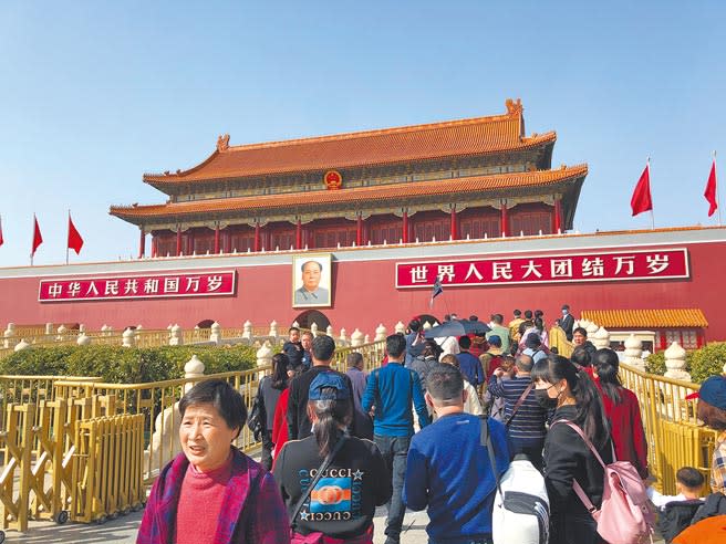 大陸遊客在北京天安門城樓毛澤東畫像前拍照。（許依晨攝）