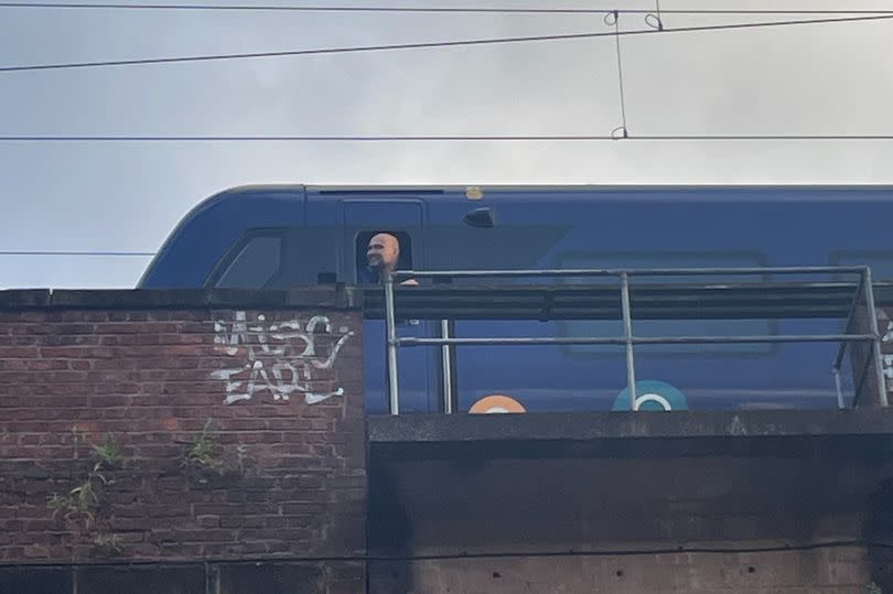 A conductor watches the show as the train stops momentarily above the venue -Credit:MEN