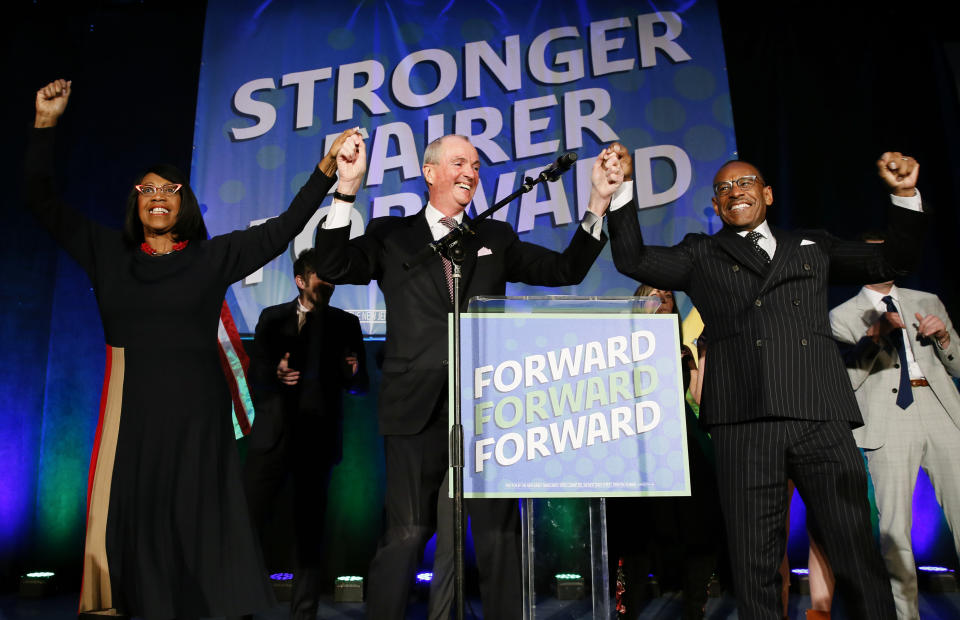 Lt. Gov. Sheila Oliver, left, New Jersey Gov. Phil Murphy, center, and LeRoy Jones, chairman of the state's Democratic committee, right, celebrate at Convention Hall after Murphy won the gubernatorial race against Jack Ciattarelli, Wednesday, Nov. 3, 2021, in Asbury Park, N.J. (AP Photo/Noah K. Murray)