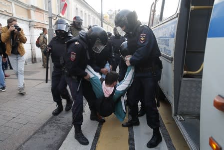 Law enforcement officers detain a man after a rally to demand authorities allow opposition candidates to run in a local election in Moscow