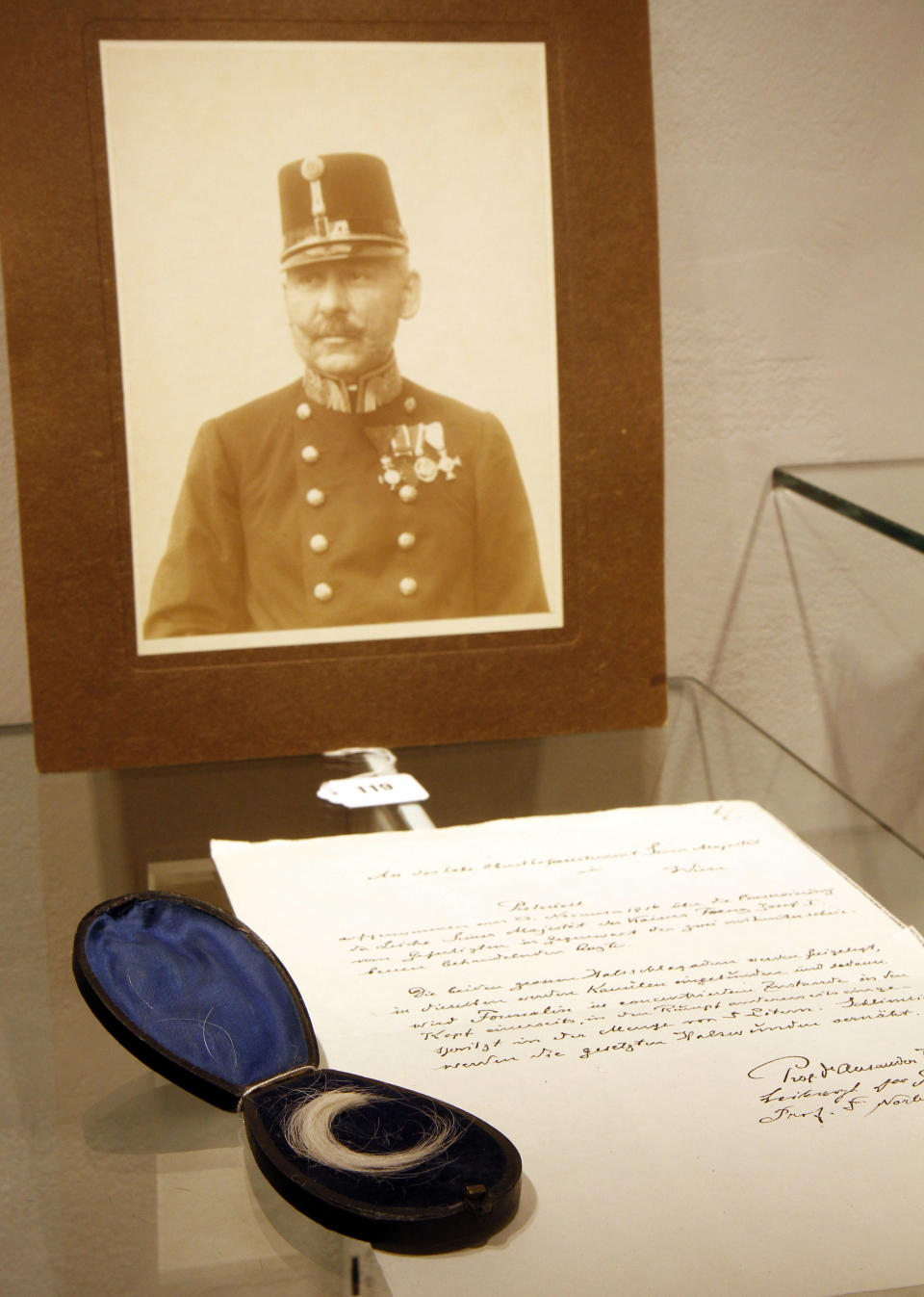 A lock of hair from Austrian Emperor Franz Josef, pictured in background on display, at an auction house, in Vienna, Austria, Thursday, April 25, 2013. Bidders looking for a pair of mended underwear worn by a former emperor came away disappointed Thursday from an auction of Austrian imperial memorabilia. But a lock of his hair was on offer, and went under the hammer for nearly 14,000 euros (around $18,000) , more than 20 times its listed worth. Vienna's prestigious Dorotheum auction house had said Emperor Franz-Josef's linen would be put on the block, suggesting there was a least a chance that one of the parsimonious ruler's patched undergarments would be put on sale. (AP Photo/Ronald Zak)