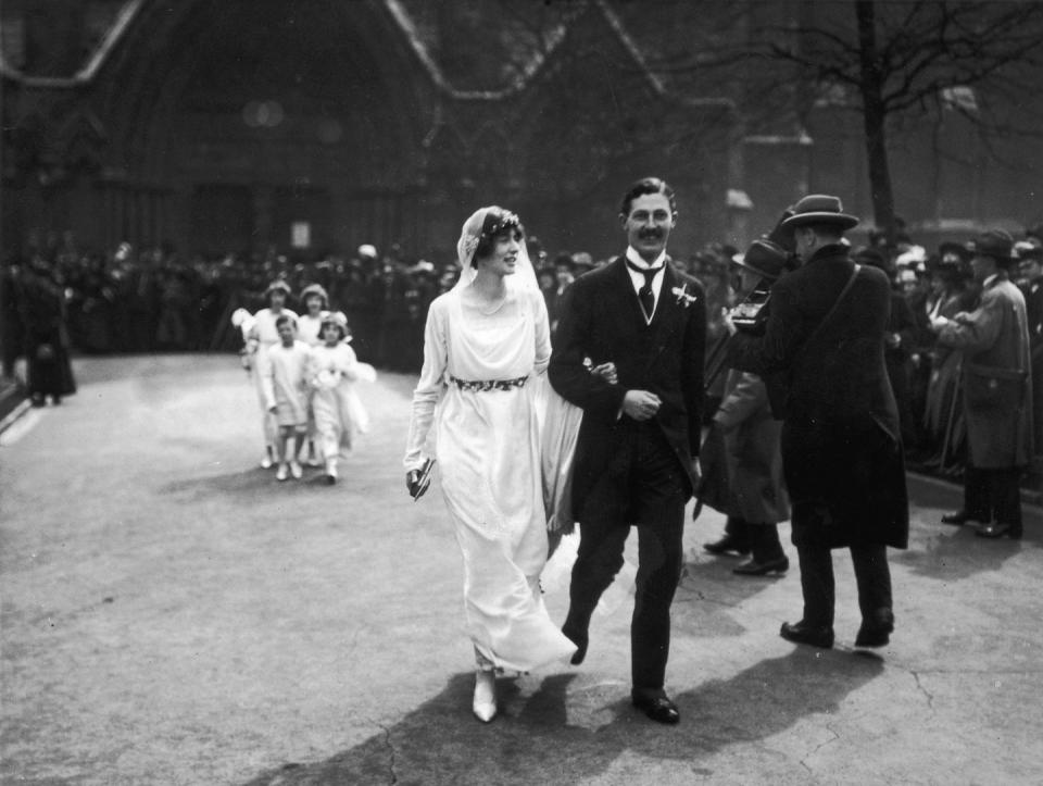 <p>Newlyweds, (soon-to-be) British Prime Minister Harold Macmillan and his wife Dorothy Cavendish, walk through the streets on their wedding day in April 1920.</p>