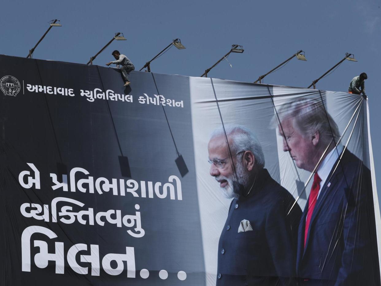 An Indian worker installs a giant hoarding welcoming US President Donald Trump ahead of his visit, in Ahmadabad, India: AP