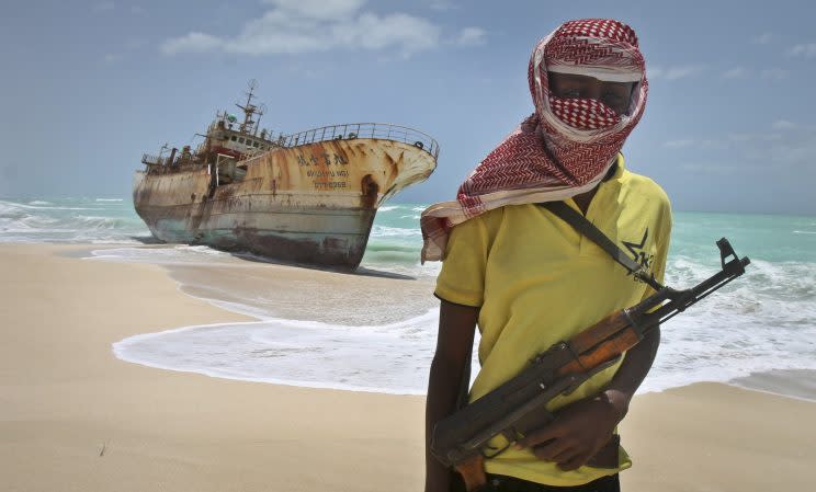 Masked Somali pirate Hassan stands near a Taiwanese fishing vessel in 2012. [Farah Abdi Warsameh/AP/REX/Shutterstock]