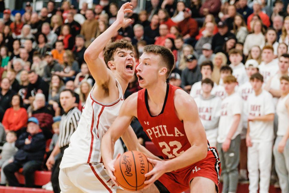 New Philadelphia's Carter Vandall looks to line up a shot during the game against Dover as Jacob Hanner defends, Wednesday, Jan. 11.