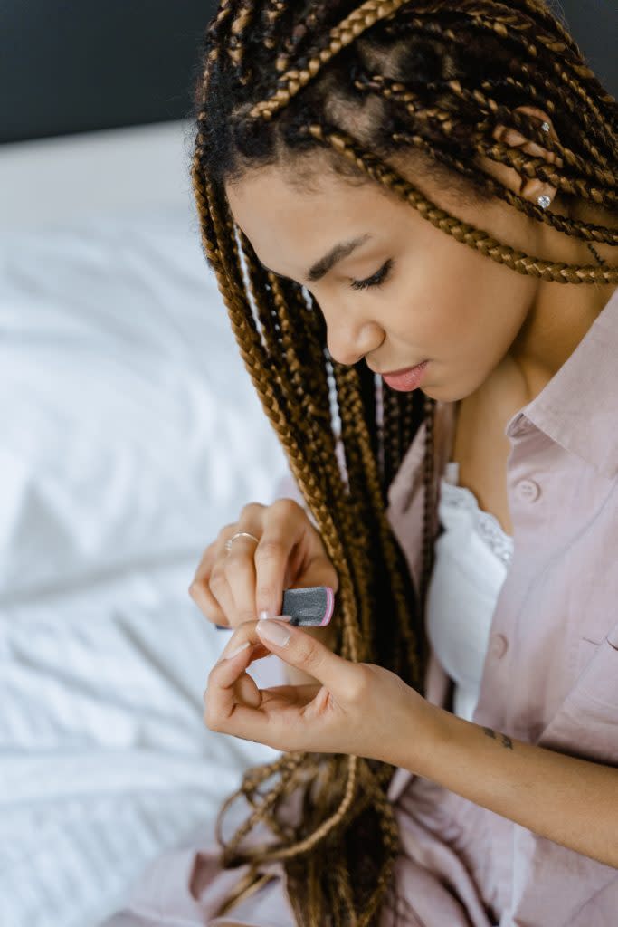 Black woman filing her nails