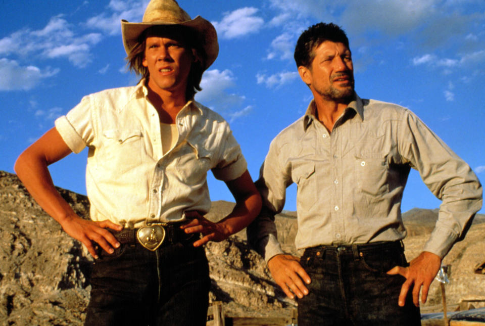 Valentine and Earl looking concerned, standing in the desert at sundown