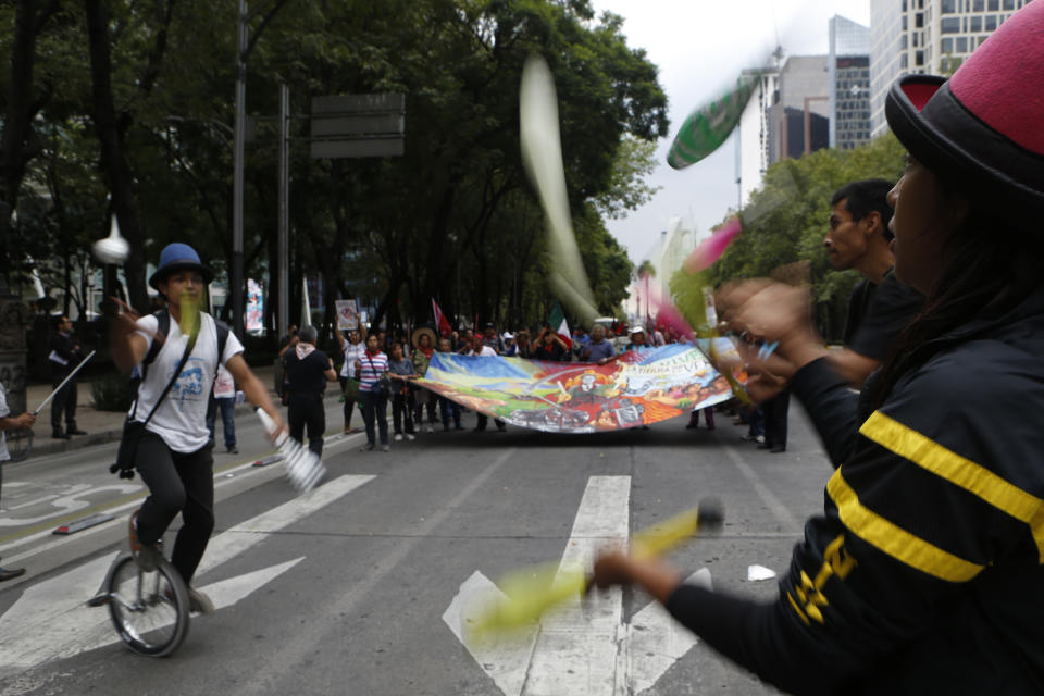 Jugglers join a protest by residents who live in Atenco who are against the construction of a new airport near their community, in Mexico City, Thursday, Aug. 23, 2018. Demonstrators marched through Mexico City Wednesday to protest a $15.7-billion airport project that threatens a decades-old effort to restore lakes that originally covered the valley. (AP Photo/Marco Ugarte)