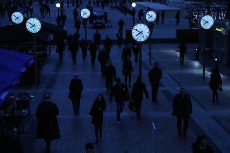 Workers walk to work during the morning rush hour in the financial district of Canary Wharf in London, Britain, January 26, 2017. REUTERS/Eddie Keogh