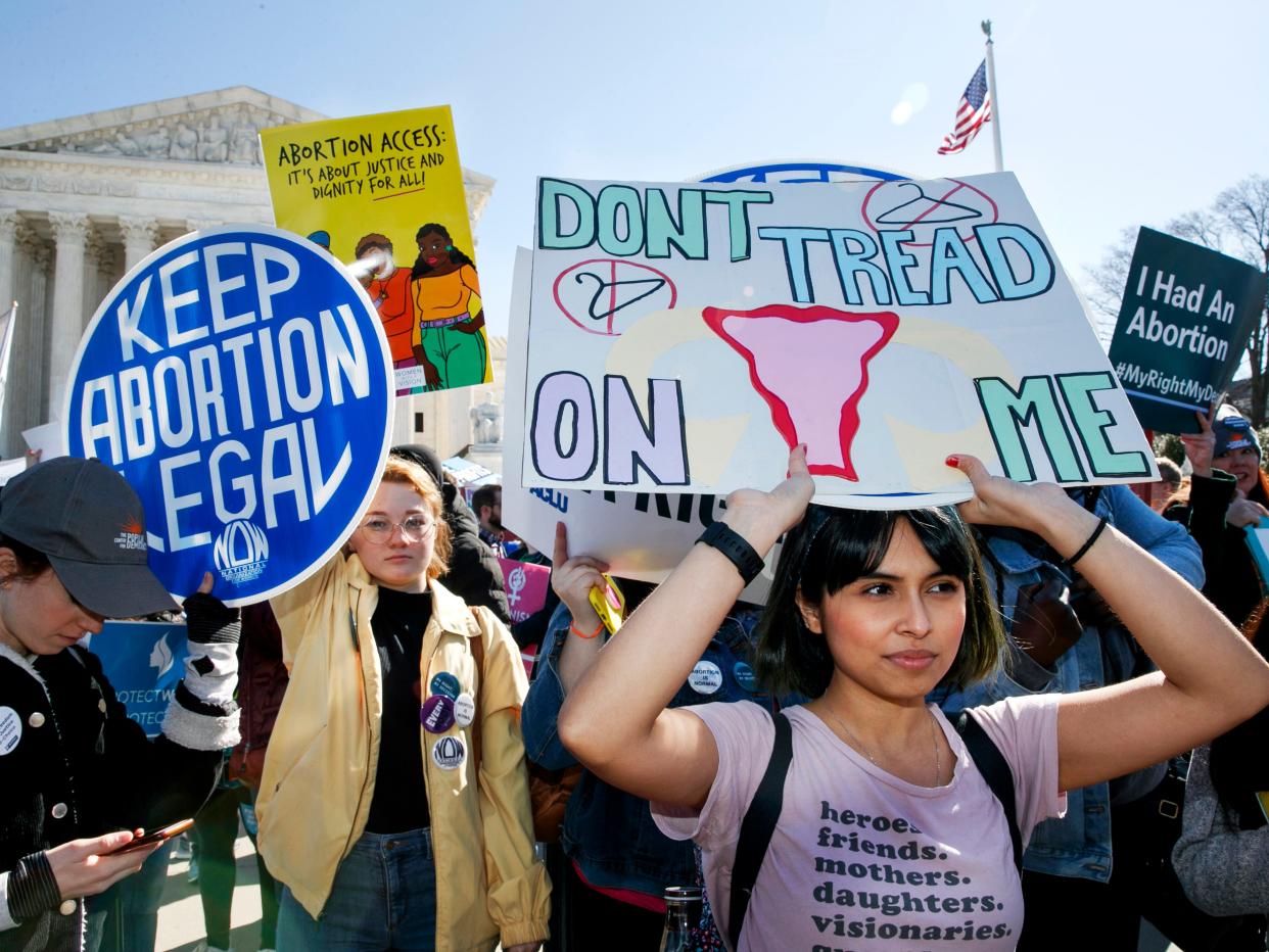 FILE - In this Wednesday, March 4, 2020 file photo, abortion rights demonstrators including Jaylene Solache, of Dallas, Texas, right, rally outside the Supreme Court in Washington. In some states, the 2020 COVID-19 coronavirus outbreak has fueled attempts to ban abortions. Where the procedure remains available, some abortion providers report increased demand, often from women distraught over economic stress and health concerns linked to the pandemic. (AP Photo/Jacquelyn Martin)