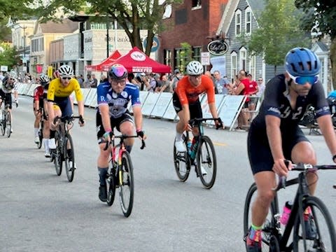 A photo of Wolfgang Brandl (blue jersey) approaching the lap marker and finish line.