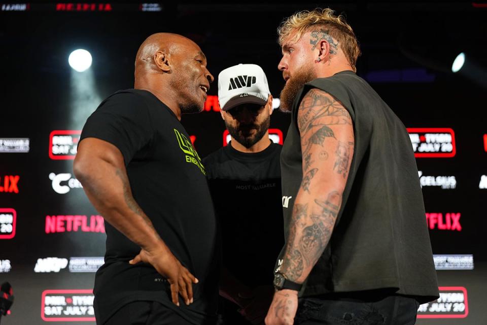 Mike Tyson and Jake Paul pose onstage during the press conference for their upcoming fight.