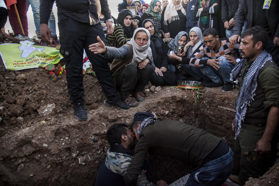 FILE - In this March 10, 2010, file, photo, people attend the funeral of a Syrian Democratic Forces fighter who was killed in a battle with remnants of the Islamic State group in eastern Syria, in the town of Qamishli. Islamic State militants in Iraq and Syria are stepping up attacks, taking advantage of governments preoccupied with the economic and health impact of the coronavirus. Security officials in Iraq say attacks are up fivefold over last year, as the group exploits security gaps linked to the virus lockdown and a U.S. troop drawdown in the country’s north. (AP Photo/Baderkhan Ahmad, File)