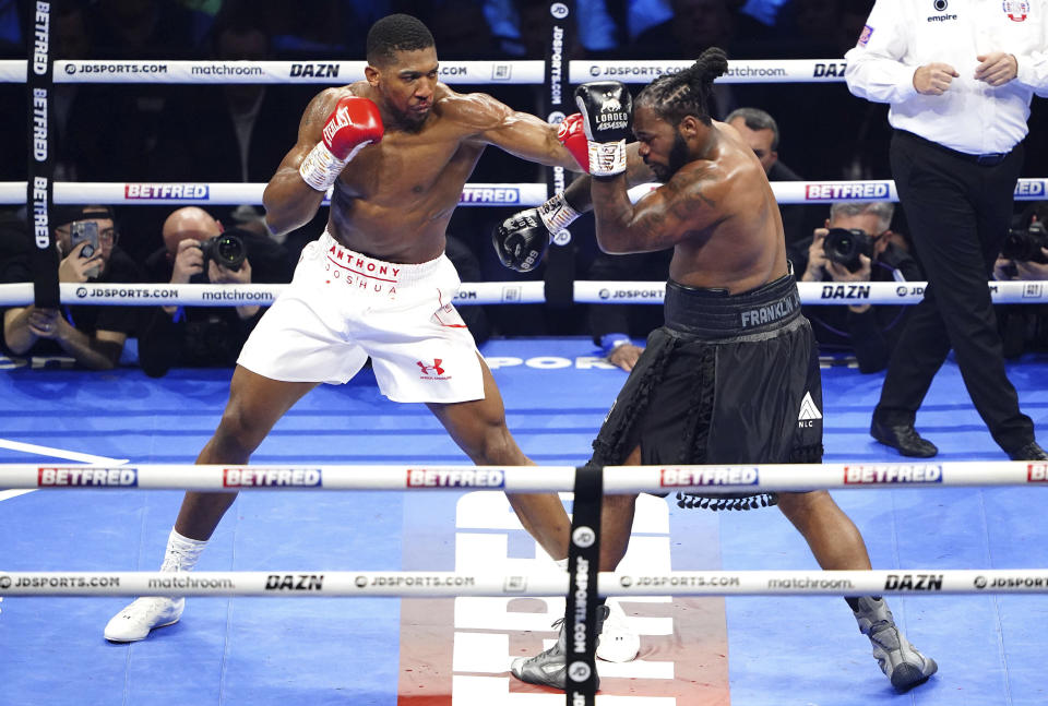 Anthony Joshua, left, strikes Jermaine Franklin during a heavyweight boxing match at The O2, Saturday, April 1, 2023 in London. (Zac Goodwin/PA via AP)