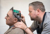 <p>Engineered Arts prosthetic expert Mike Humphrey checks on Fred, a recently completed Mesmer robot that was built at the company’s headquarters in Penryn on May 9, 2018 in Cornwall, England. Founded in 2004, the Cornish company operating from an industrial unit near Falmouth, is a world leader in life sized commercial available humanoid robots for entertainment, information, education and research. The company has successfully sold its the fully interactive and multilingual RoboThespian robot around the world to science centres, theme parks and visitor attractions, and also to academic and commercial research groups where they are used as research and development platforms. (Photo from Matt Cardy/Getty Images) </p>