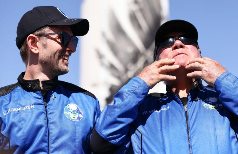 &quot;Star Trek&quot; actor William Shatner gestures as Planet Labs co-founder Chris Boshuizen looks on after their Blue Origin flight to space on October 13, 2021.