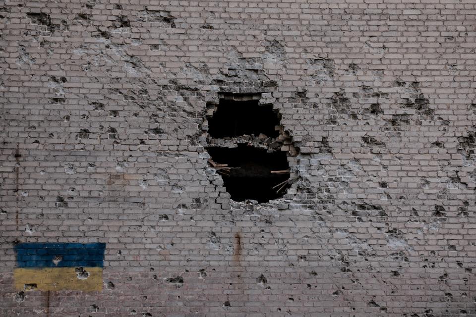 A view of Ukrainian national flag painted on the wall of a heavily damaged building in the frontline town of Chasiv Yar (via REUTERS)