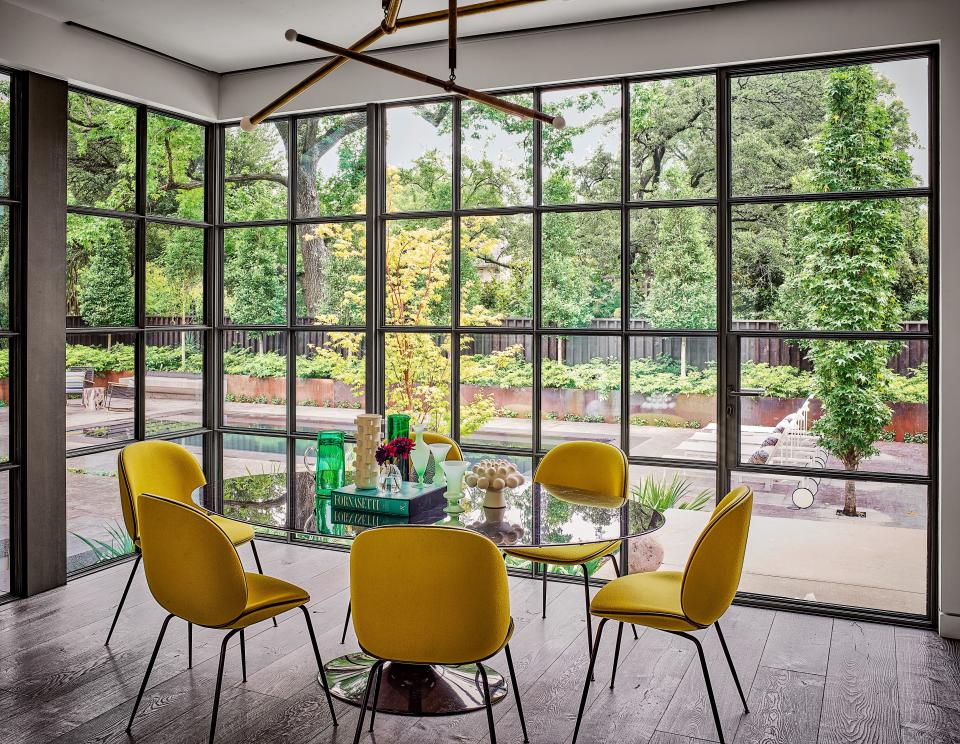 In the breakfast nook, an Apparatus chandelier is grouped with Gubi side chairs and an Eero Saarinen table from Design Within Reach.