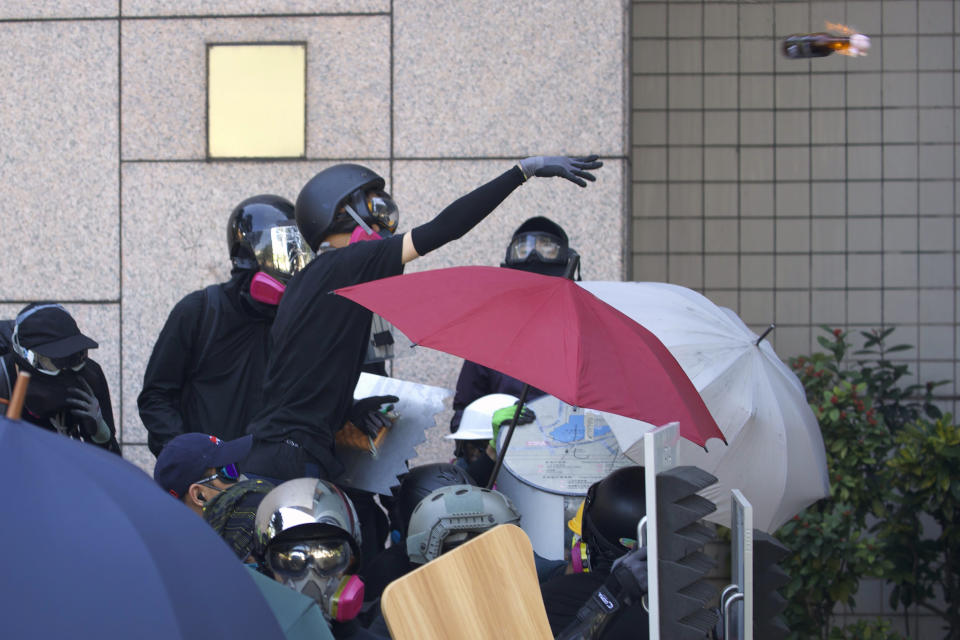 A protestor hurls a molotov cocktail at police on the campus of the Hong Kong Polytechnic University in Hong Kong, Sunday, Nov. 17, 2019. (AP Photo/Ng Han Guan)