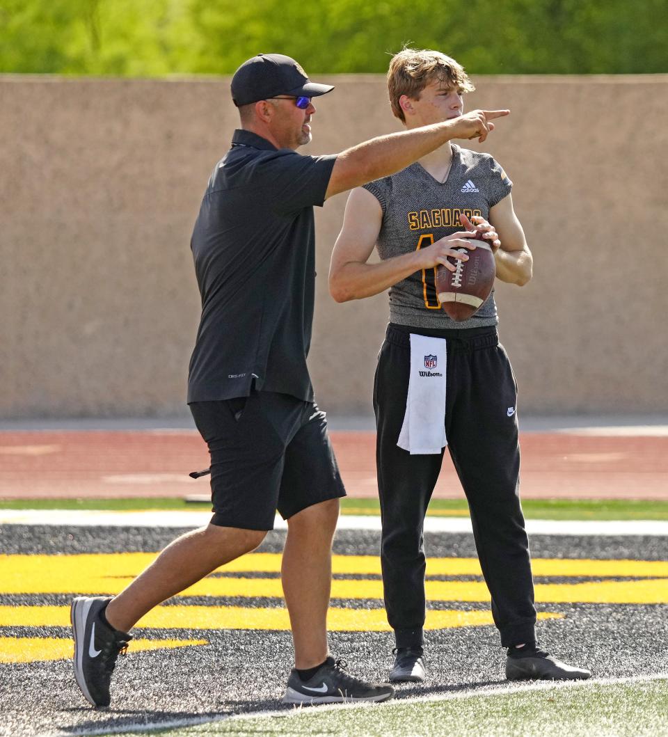 Saguaro head coach Zak Hill works with quarterback Mason Bray (14) during a spring practice at Saguaro High School in Scottsdale on April 25, 2023.