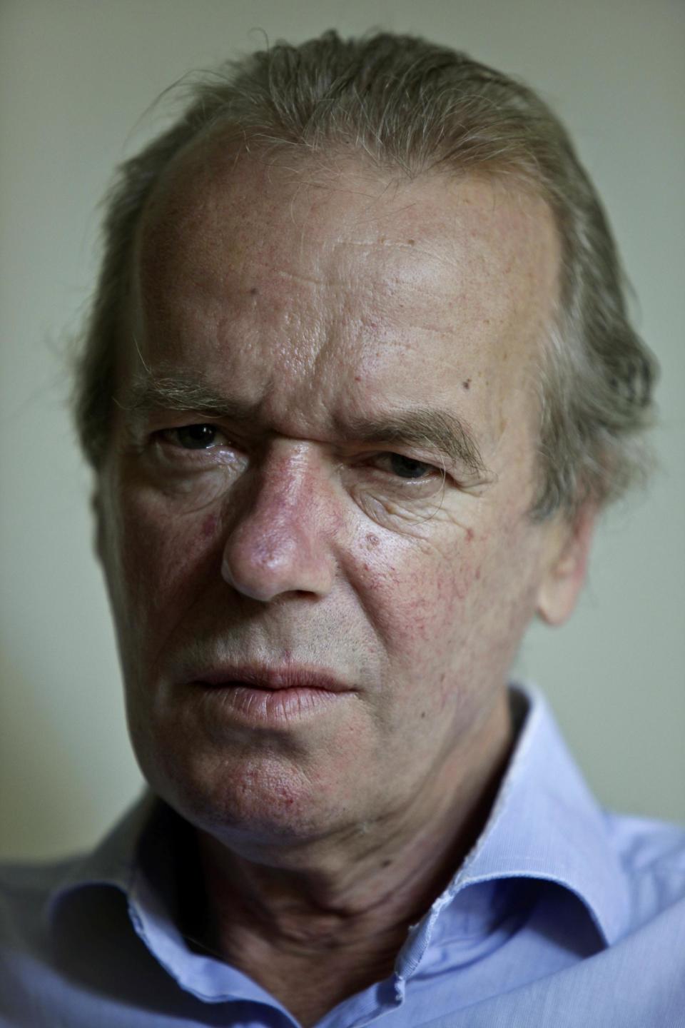 This Aug. 17, 2012 photo shows British novelist Martin Amis pose in the living room of his new home in the Brooklyn borough of New York. Amis’s new novel is titled “Lionel Asbo: State of England.” (AP Photo/Bebeto Matthews)