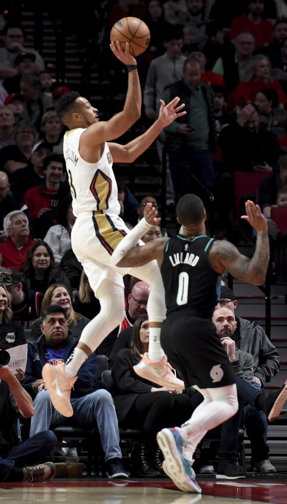 New Orleans Pelicans guard CJ McCollum, left, shoots over Portland Trail Blazers guard Damian Lillard, right, during the first half of an NBA basketball game in Portland, Ore., Wednesday, March 1, 2023. (AP Photo/Steve Dykes)